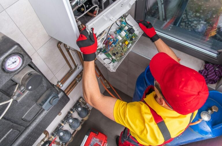 Technician servicing the control board of a wall-hung boiler