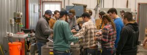 Students actively participating in hands-on HVAC training at Su&rsquo;Coy Community Learning Center, demonstrating collaboration and focused learning in a dynamic setting