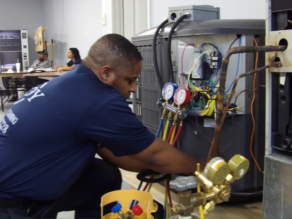 HVAC student working on air conditioning unit during hands-on training at Su’Coy CLC.