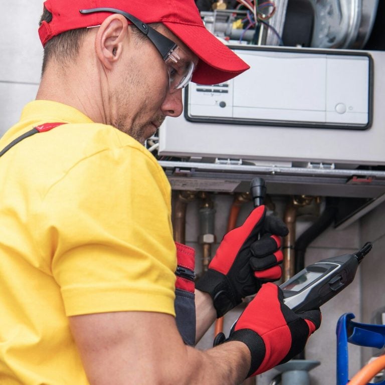 Technician testing a water heater installation for gas leaks